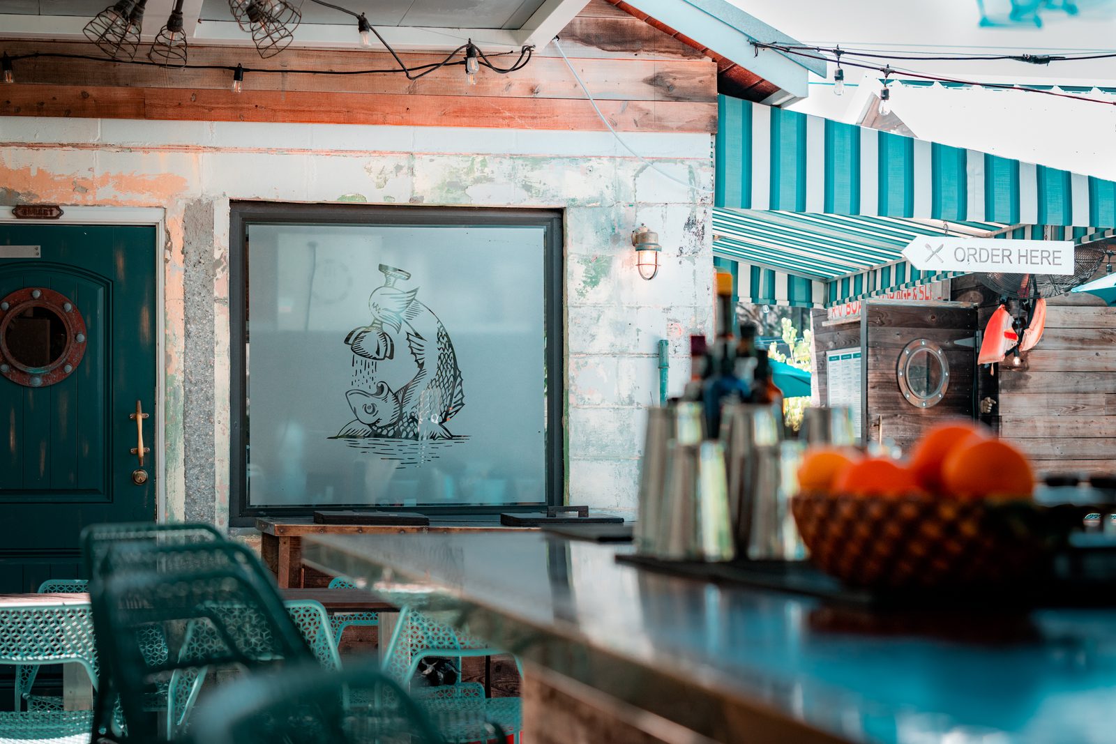 The Trophy Fish bar with teal stools and nautical art.